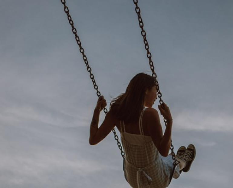 a girl playing on the swings (very hopeful and cheerful mood representing the dream)