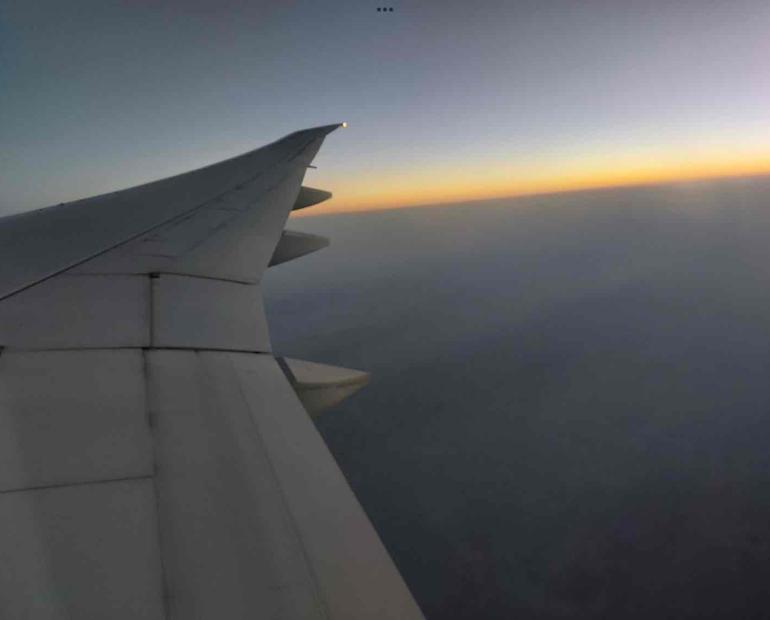 Gazing out at the surreal hues of the horizon from the window of the plane