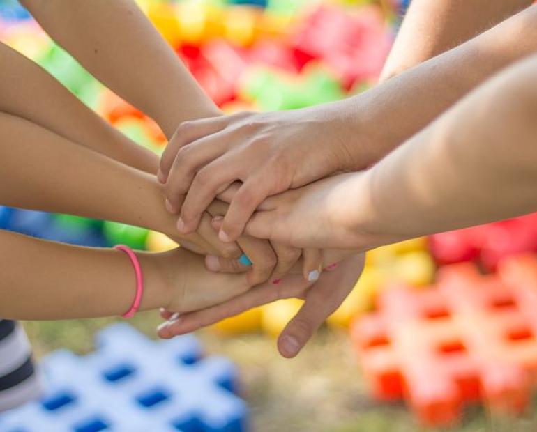 A picture of some kids holding hands, showing unity and kindness.