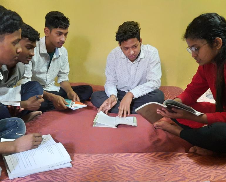 Teacher teaching four students 