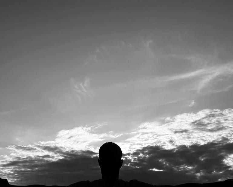 A man with hands spread out and the cloud as background.