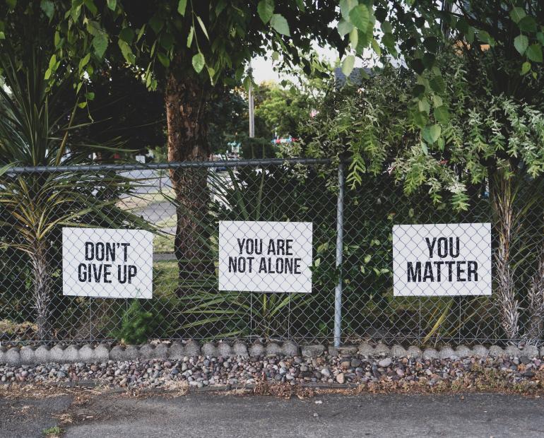 Signs that say "Don't give up", "You are not alone", "You matter"