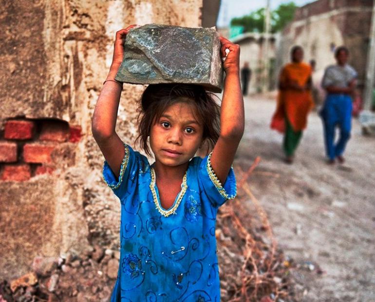 a child laborer working at a construction site in India 