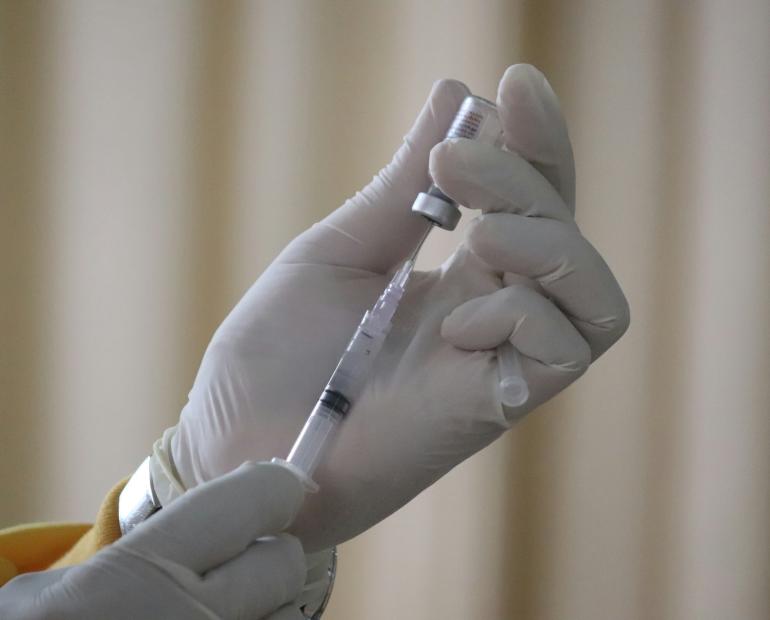 A person preparing a vaccine shot.