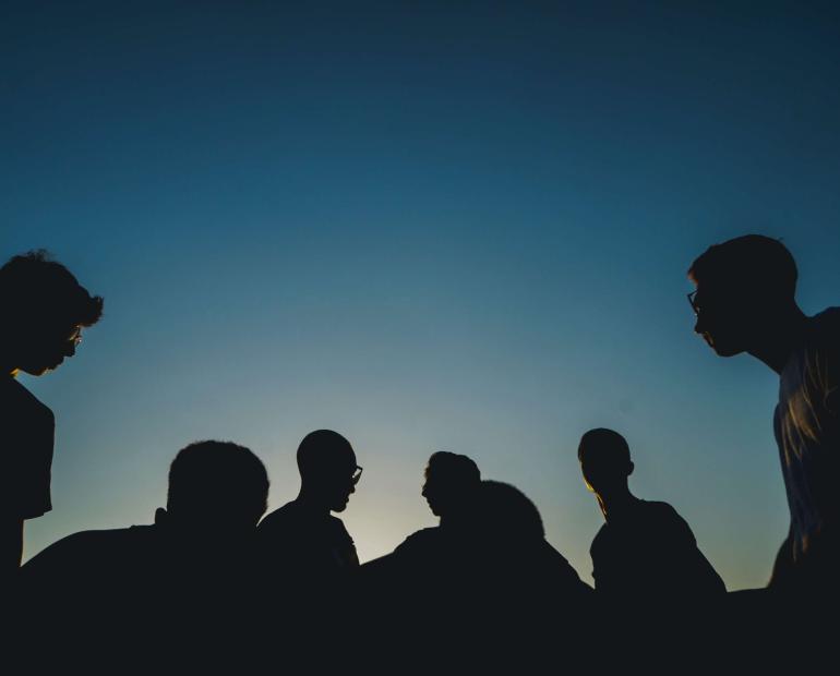 The shadow of a group of young people talking.