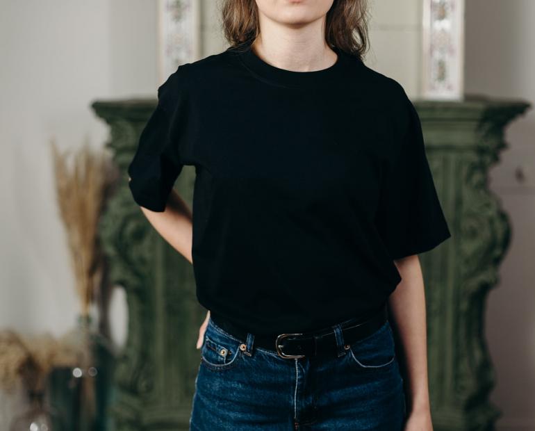 Person wearing black T-shirt and denim jeans