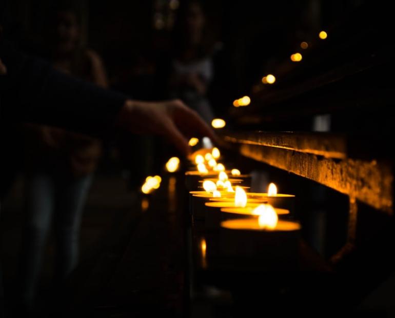 People lighting up candles together.