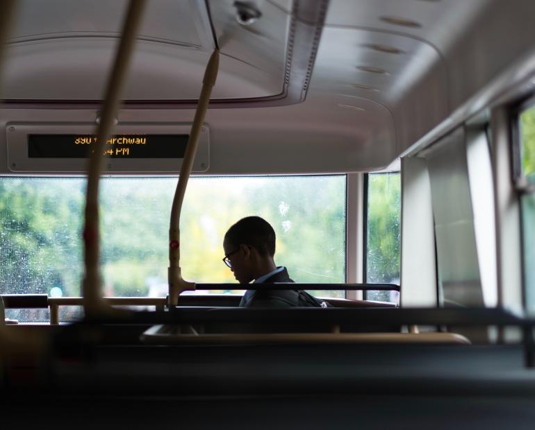 Black child gets onto an empty bus.