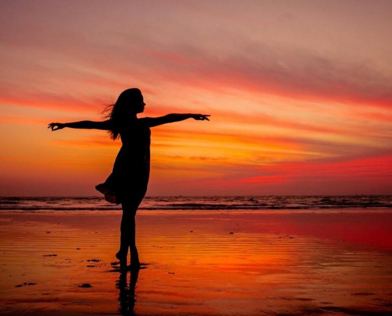 Woman standing on the beach during sunset