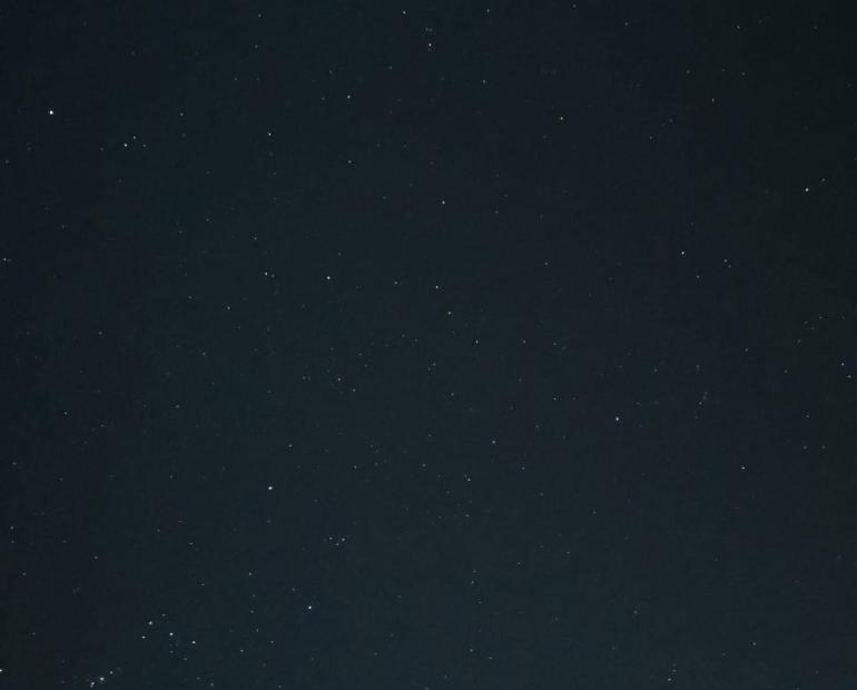 Dark sky with tiny specks for stars scattered around it